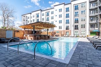A large swimming pool in front of apartment buildings.